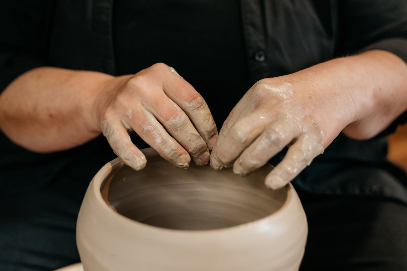 Handen aan het draaien op de pottenbakkersschijf