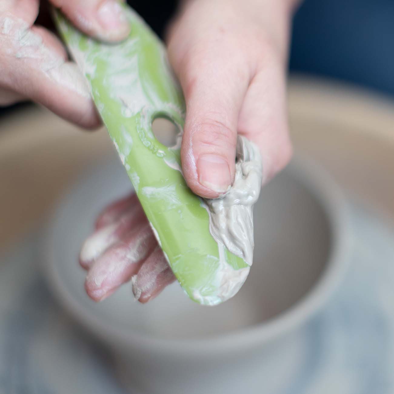 Anja maakt het gereedschap schoon van klei